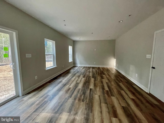 unfurnished room with dark hardwood / wood-style flooring and a healthy amount of sunlight