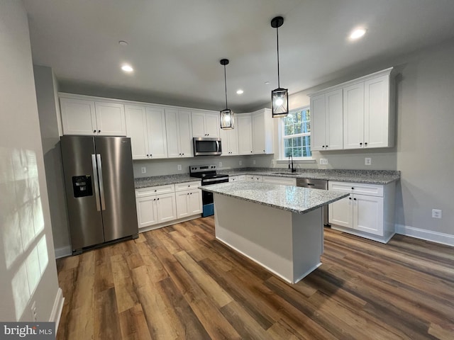 kitchen with light stone countertops, appliances with stainless steel finishes, dark hardwood / wood-style floors, and white cabinets