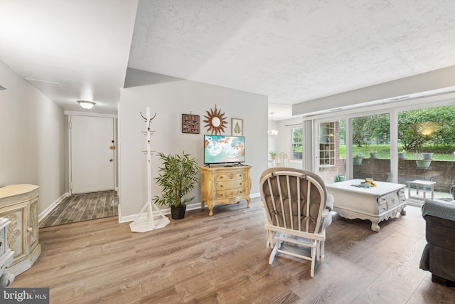 interior space with a textured ceiling and hardwood / wood-style floors