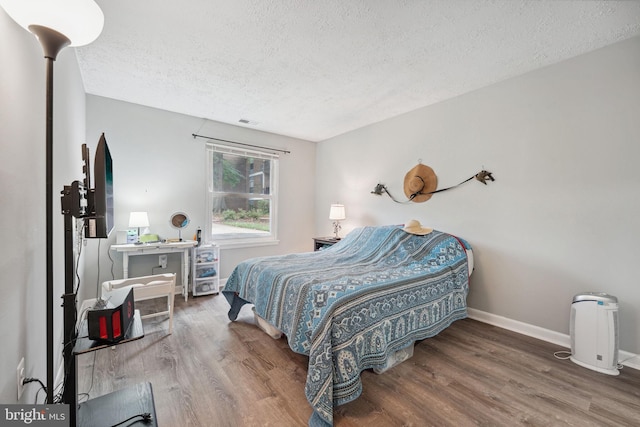 bedroom with hardwood / wood-style flooring and a textured ceiling