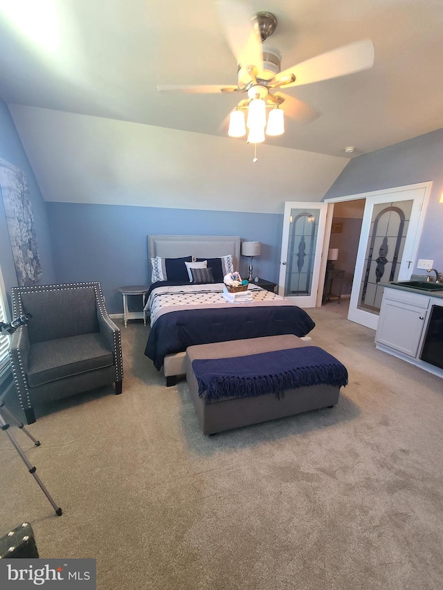 carpeted bedroom featuring ceiling fan, sink, and vaulted ceiling