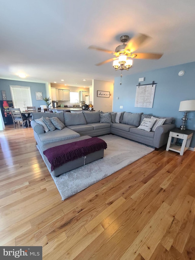 living room with ceiling fan and light hardwood / wood-style floors