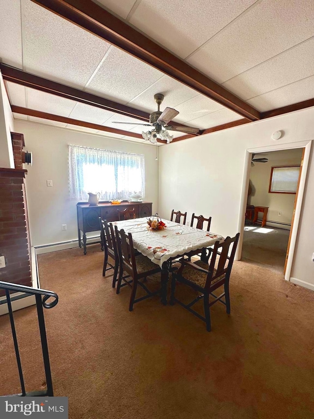 carpeted dining space with baseboard heating, beamed ceiling, and ceiling fan