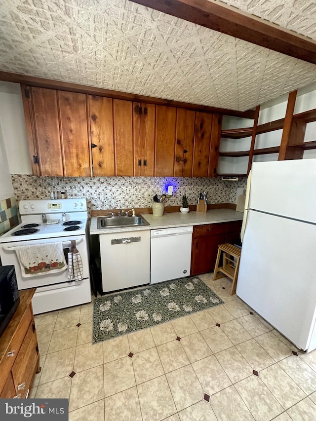 kitchen featuring light tile patterned flooring, sink, backsplash, and white appliances