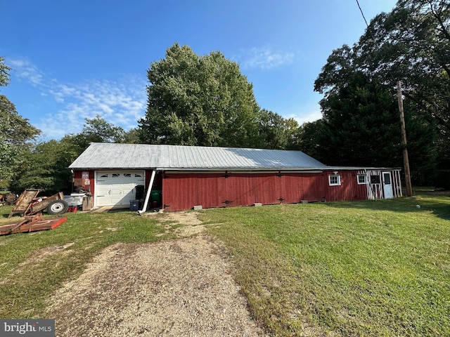 view of outdoor structure featuring a garage and a lawn