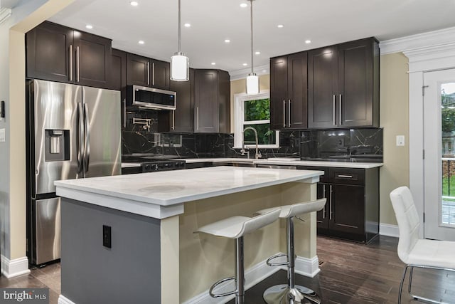 kitchen with appliances with stainless steel finishes, decorative backsplash, a center island, and a wealth of natural light