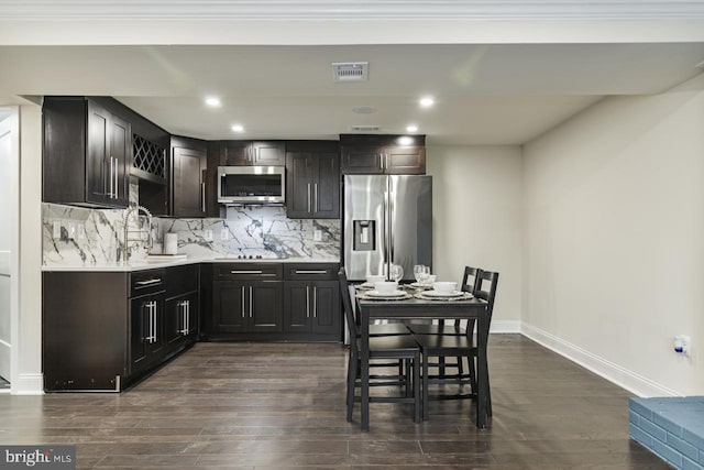 kitchen featuring dark hardwood / wood-style flooring, tasteful backsplash, sink, stainless steel appliances, and crown molding