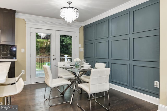 dining room with ornamental molding, an inviting chandelier, dark wood-type flooring, and french doors