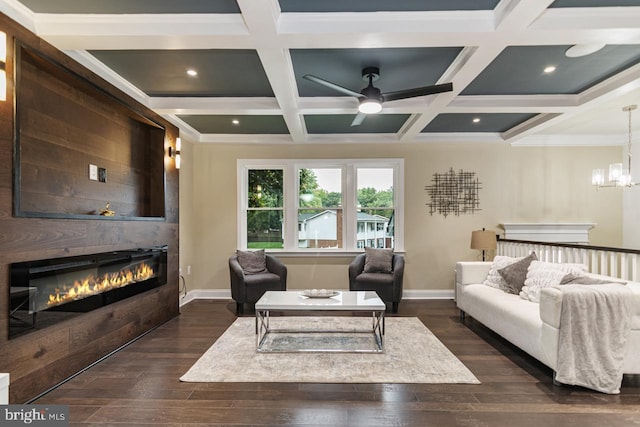 living room with ceiling fan with notable chandelier, a large fireplace, coffered ceiling, and dark hardwood / wood-style flooring