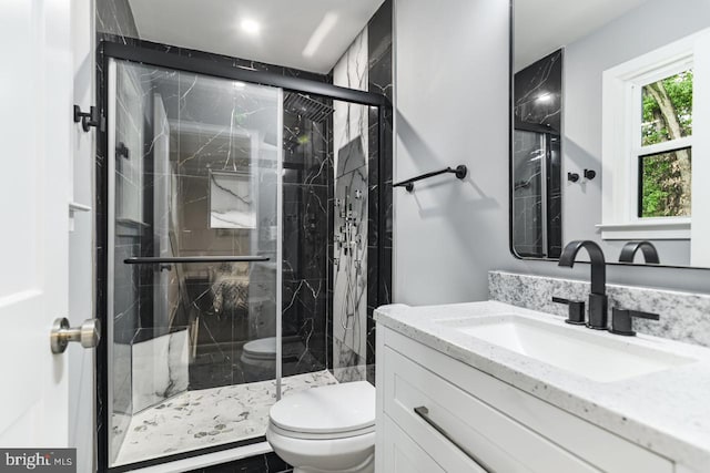 bathroom featuring vanity, toilet, and an enclosed shower