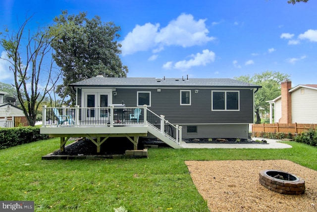 rear view of house featuring an outdoor fire pit, a deck, and a yard