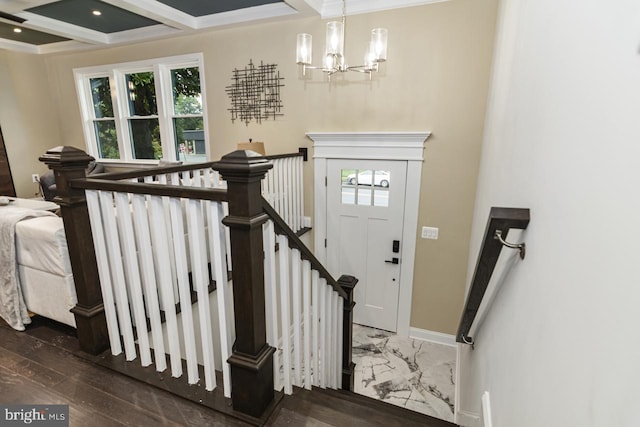 entrance foyer with coffered ceiling, dark wood-type flooring, beamed ceiling, ornamental molding, and a chandelier