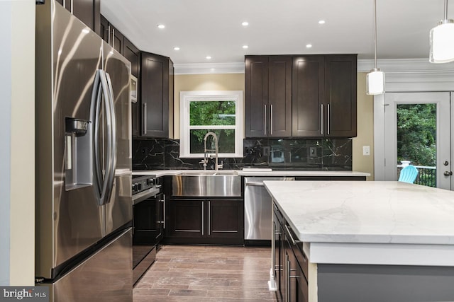 kitchen with pendant lighting, stainless steel appliances, backsplash, and sink