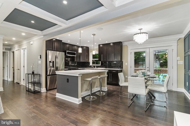 kitchen featuring appliances with stainless steel finishes, dark hardwood / wood-style floors, a center island, and pendant lighting