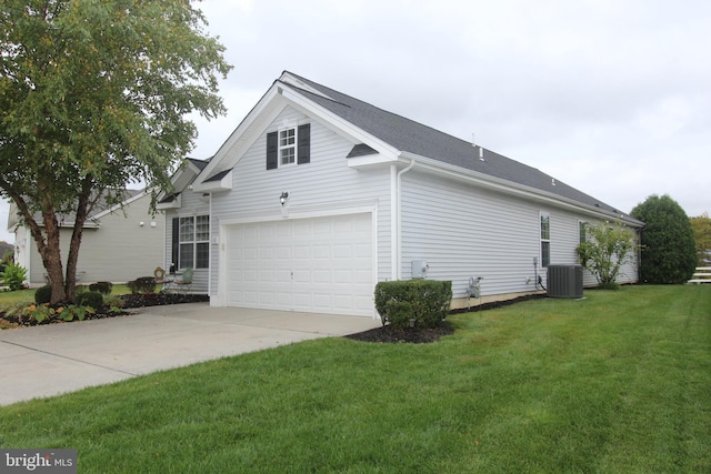 view of side of property with a lawn, central AC, and a garage