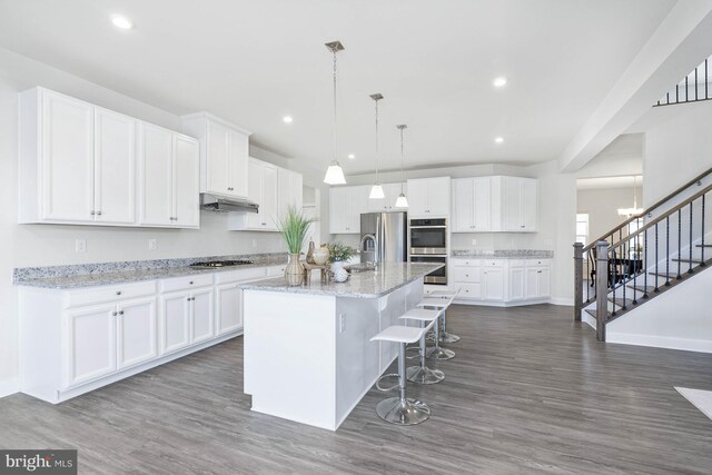 kitchen featuring white cabinets, dark hardwood / wood-style floors, and an island with sink