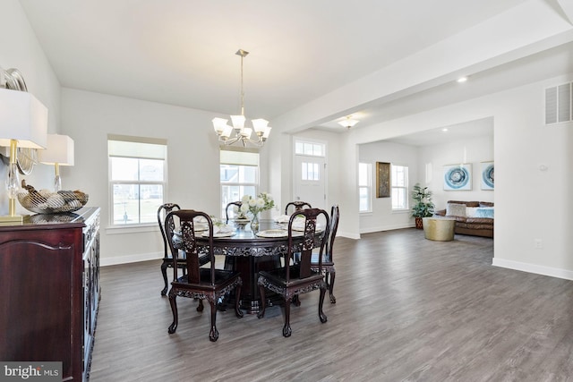 dining room with dark hardwood / wood-style floors and a notable chandelier