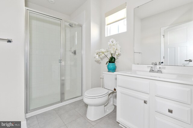 bathroom featuring toilet, vanity, tile patterned floors, and an enclosed shower