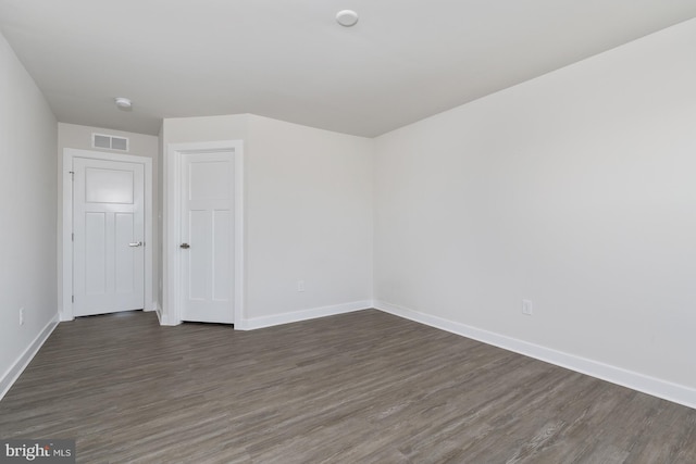 empty room with dark hardwood / wood-style flooring