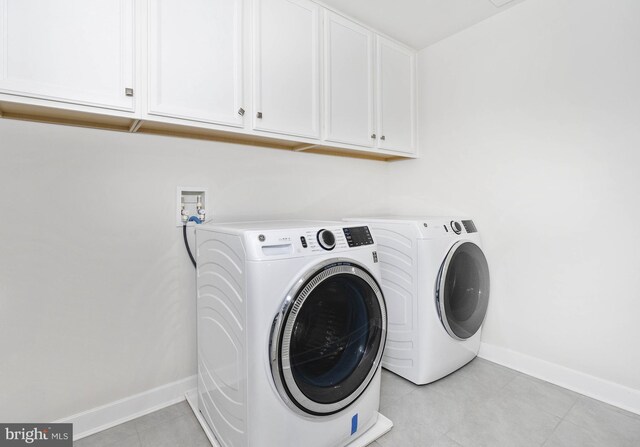 laundry area featuring cabinets and washer and clothes dryer