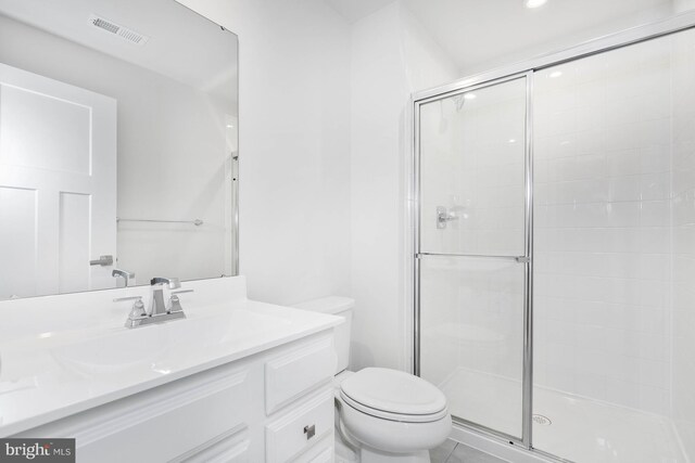 bathroom with tile patterned flooring, vanity, toilet, and a shower with shower door