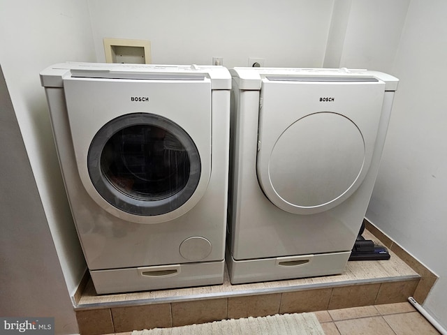 laundry area featuring light tile patterned flooring and independent washer and dryer