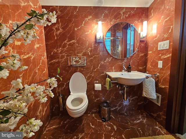 bathroom with tile walls and toilet