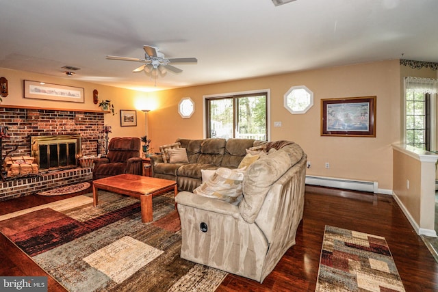 living room featuring dark hardwood / wood-style flooring, a fireplace, ceiling fan, and a baseboard heating unit