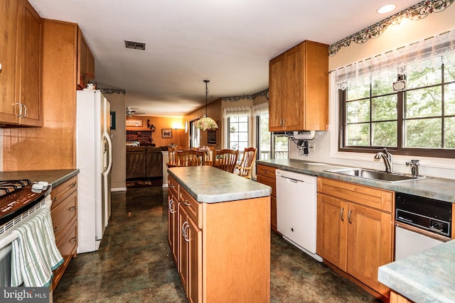 kitchen featuring pendant lighting, white appliances, sink, and a center island