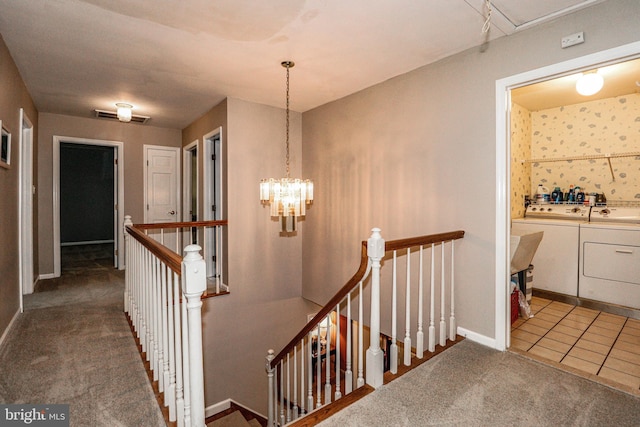 stairway with carpet flooring, separate washer and dryer, and a chandelier