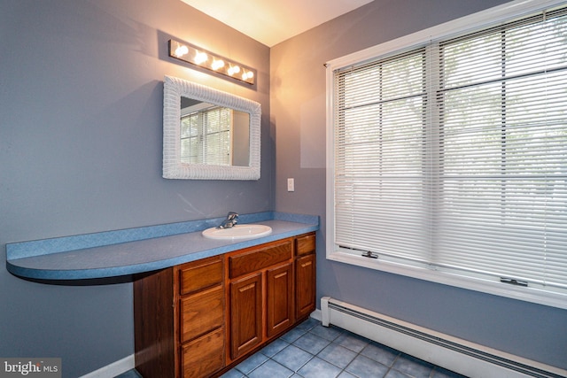 bathroom featuring baseboard heating, tile patterned flooring, vanity, and a healthy amount of sunlight