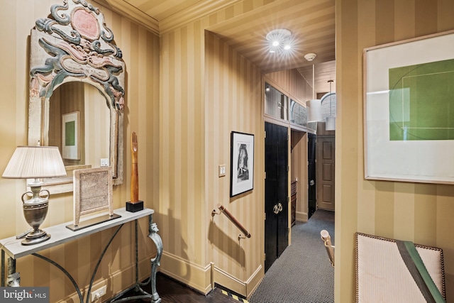 hall with dark carpet and ornamental molding