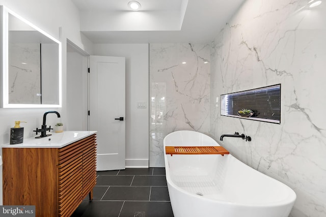 bathroom featuring vanity, tile patterned flooring, and a bath