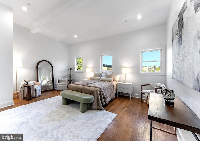 bedroom featuring multiple windows, beam ceiling, and hardwood / wood-style floors