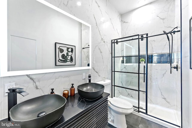 bathroom with tile walls, vanity, toilet, and an enclosed shower