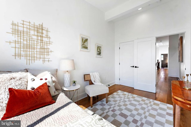 bedroom featuring a high ceiling and dark hardwood / wood-style floors