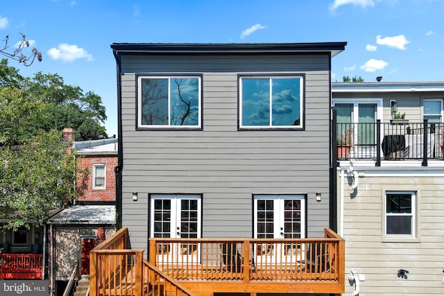 rear view of property with a balcony and a deck