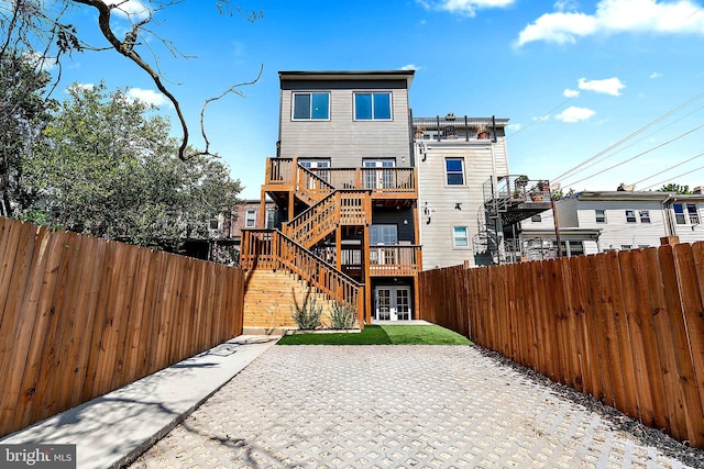 rear view of house featuring a wooden deck and a patio