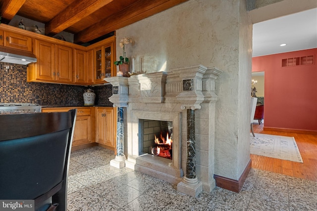 kitchen featuring beam ceiling, light hardwood / wood-style flooring, ventilation hood, wooden ceiling, and decorative backsplash