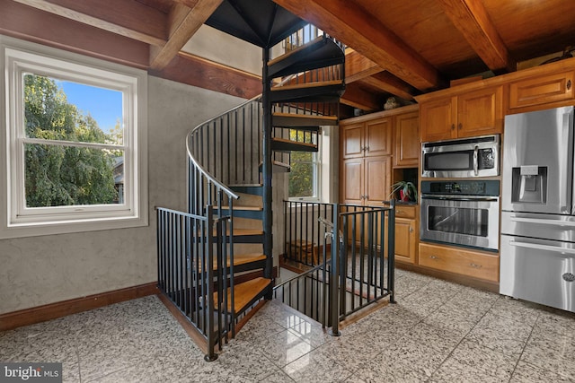 stairs featuring wooden ceiling, lofted ceiling with beams, and plenty of natural light