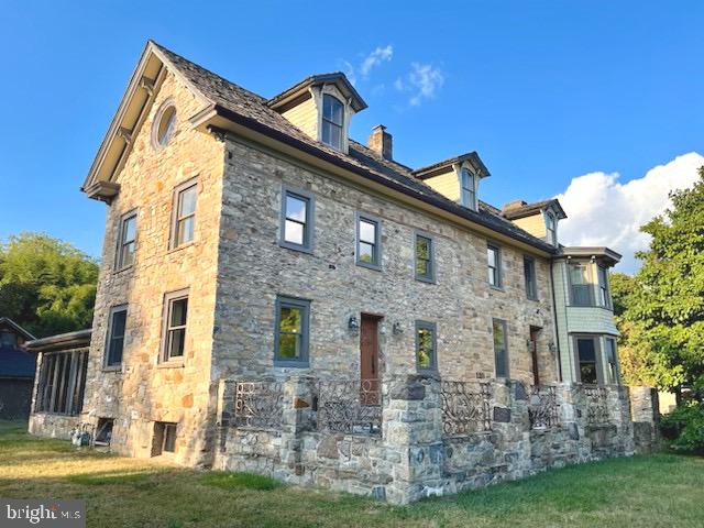 view of side of home with a yard