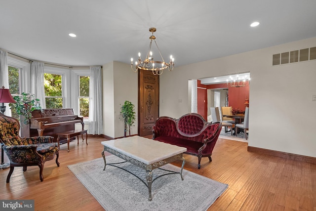 living room with light wood-type flooring and a chandelier