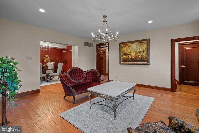 living room featuring a notable chandelier and light wood-type flooring