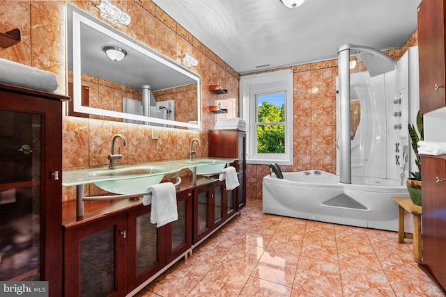 bathroom with tile walls, tile patterned flooring, vanity, and separate shower and tub