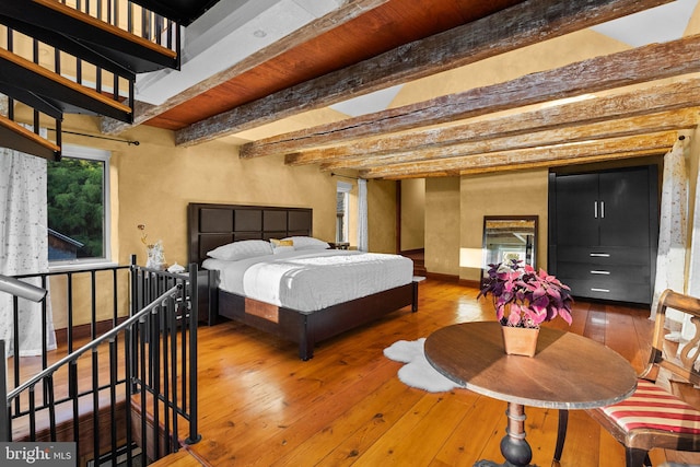 bedroom featuring beamed ceiling and hardwood / wood-style floors