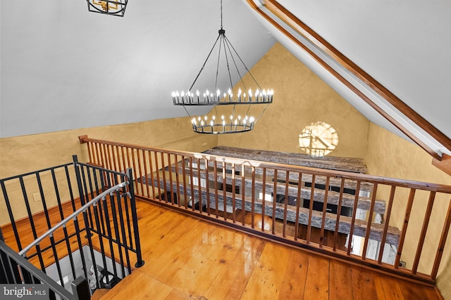 stairs featuring vaulted ceiling and hardwood / wood-style floors