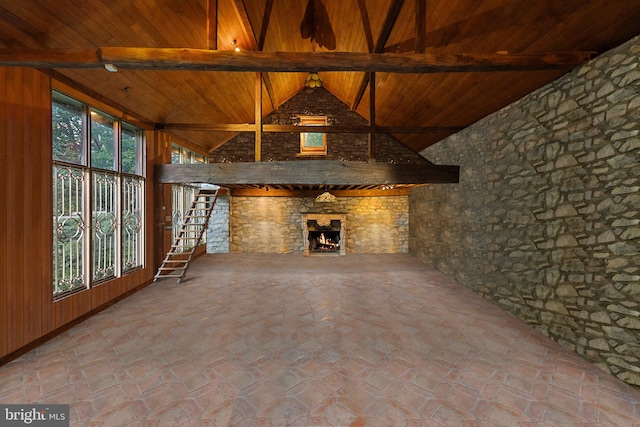 unfurnished living room with wooden ceiling, wood walls, a fireplace, and beam ceiling