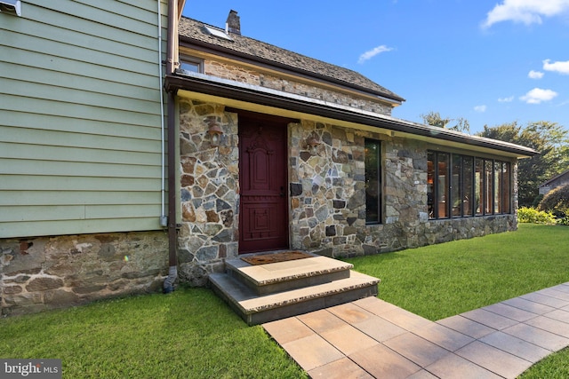 doorway to property with a lawn