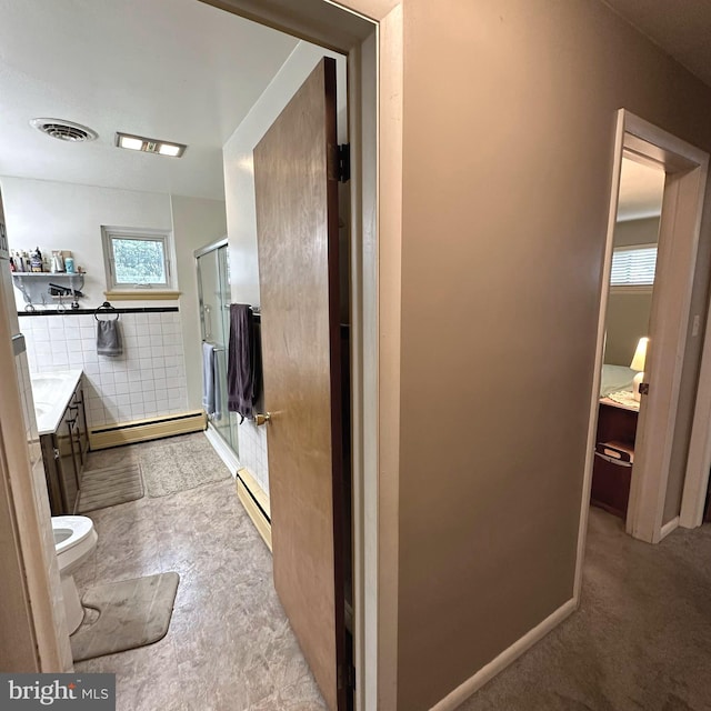 bathroom featuring vanity, a baseboard radiator, toilet, and an enclosed shower