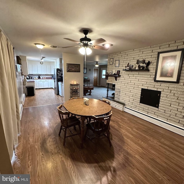 dining area featuring wood-type flooring, baseboard heating, and ceiling fan